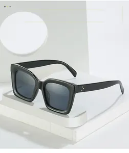 Detailansicht der schwarzen quadratischen Sonnenbrille mit goldenen Akzenten am Rahmen