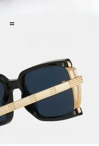 Detail of square sunglasses with black frame and golden metal temples featuring vertical stripes