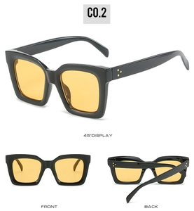 Detailansicht der quadratischen schwarzen Sonnenbrille mit gelben Gläsern und Nieten