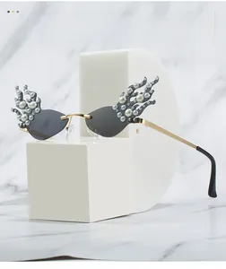 Detailed macro view of flame-shaped sunglasses with grey lenses and pearl embellishments