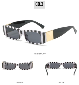 Close-up of black and white striped sunglasses with gold metal hinge detail
