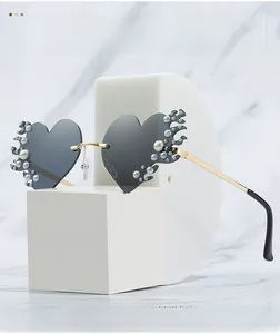 Détail de lunettes de soleil en cœur avec décor de flammes en perles et verres gris