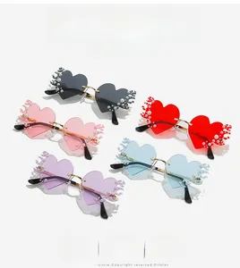Détail de lunettes de soleil sans monture en forme de cœur avec perles et bords flammes