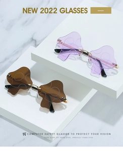 Detail of mushroom-shaped rimless sunglasses in purple and brown with gold metal arms