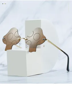 Close-up of mushroom-shaped rimless sunglasses with brown lenses and golden metal temples