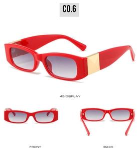Detail of red rectangular sunglasses featuring gold pyramid accents and gradient lenses
