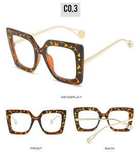 Detail view of square tortoiseshell frame with golden metal temples and pearl accents