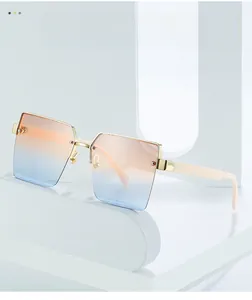 Detail of pink-blue gradient lenses on square frame sunglasses with gold metal accents