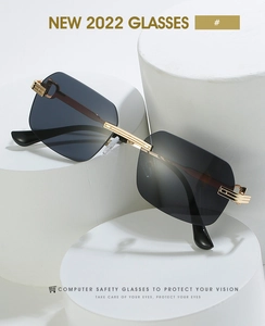 Detail of rimless sunglasses with polygon grey lenses and gold metal temples