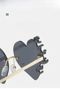 Détail de lunettes de soleil en forme de cœur avec verres flamme et monture dorée