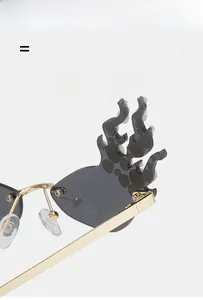 Detail of flame-shaped sunglasses with inlaid pearls and gold metal hinges