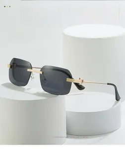 Detail of rimless rectangle sunglasses with gold C-shape metal hinges and grey lenses