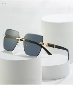 Detail of rimless square sunglasses with gradient grey lenses and golden metal bridge