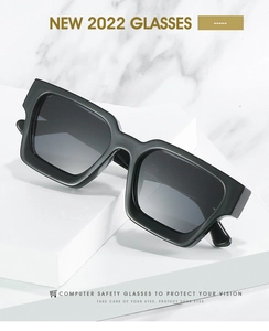 Detail of trendy thick black square frame sunglasses on white marble display stand