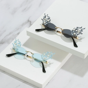 Flame-shaped sunglasses with DIY pearls and rhinestones on geometric white marble display