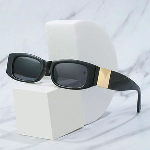 Chic black rectangular sunglasses with gold pyramid studs on a marble background