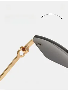 Macro detail of golden metal hinge and grey lens on rimless sunglasses frame