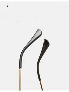 Close-up of curved golden metal temples with black tips on rimless sunglasses