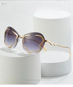 Gros plan sur lunettes de soleil sans monture à verres dégradés violets et branches dorées