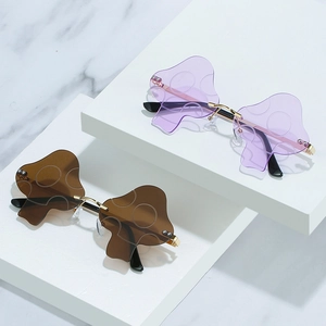 Chic mushroom shaped rimless sunglasses with gold metal frame on a white marble display
