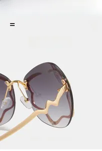 Détail de lunettes nuage sans monture avec branches vagues dorées et verres dégradés