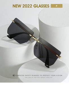 Detail of rimless square sunglasses with gold metal bridge and dark gradient lenses