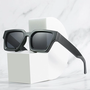 Retro oversized square black frame sunglasses with dark gray lenses on marble background