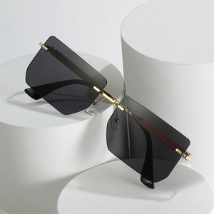 Frameless square gradient sunglasses with gold metal accents on white pedestals