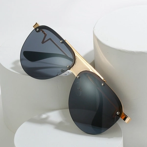 Klassische Pilotensonnenbrille aus Goldmetall mit dunklen Gläsern auf weißen Sockeln