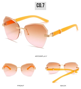 Detail view of rimless geometric sunglasses with orange-pink gradient lenses and gold hinges