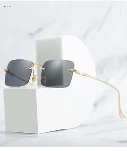 Détails des branches en métal doré gravé sur des lunettes de soleil sans monture