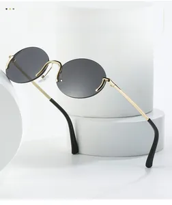 Détail de lunettes de soleil ovales sans monture avec branches en métal doré chic