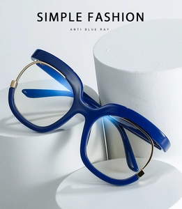 Detail of dark blue oversized frames with gold metal trim and anti-blue light lenses