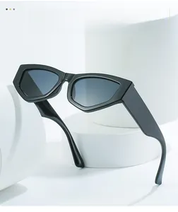 Detail of stylish black irregular cat-eye sunglasses with gradient lenses on white props