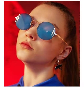 Détail de lunettes de soleil rondes avec verres bleus et accents de croix dorées