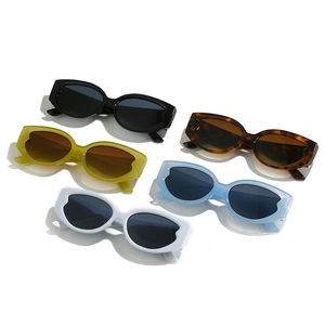 Five pairs of oval cat-eye sunglasses in various colors with metallic accents on white base