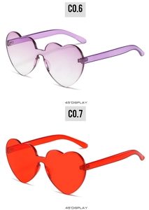 Detail view of heart-shaped sunglasses in gradient pink and solid red at 45-degree angle