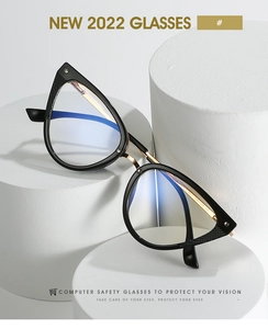 Detailed macro view of black cat-eye glasses frame with golden metal spring hinges