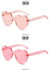 Detail view of pink heart-shaped rimless sunglasses at a 45-degree angle in soft candy tones