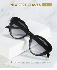 Close-up of black cat-eye computer safety glasses on minimalist marble background