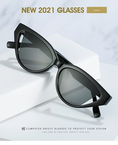 Detail of small cat-eye sunglasses with black resin frame on marble background