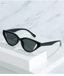 Macro detail of retro black cat-eye sunglasses with glossy frames on a white pedestal