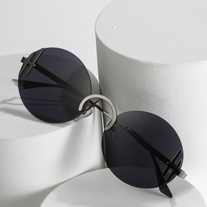 Lunettes de soleil rondes sans monture avec verres foncés et détails croix en métal