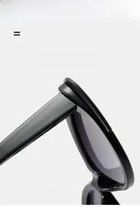 Detail of black cat eye sunglasses showing light elastic frame and polished hinge