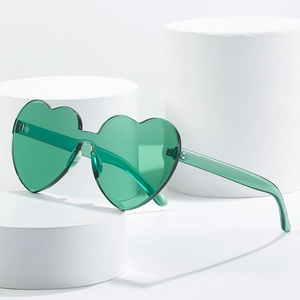 Trendy translucent green heart-shaped oversized sunglasses on a minimalist white display