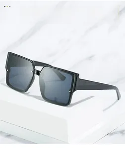 Detail view of large black square sunglasses with silver rivet accents on a marble stand
