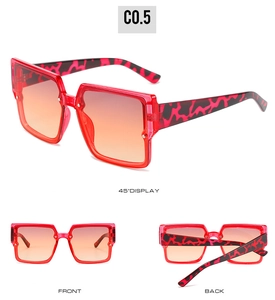Detail view of red semi-transparent square sunglasses with gradient lenses and leopard arms
