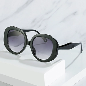 Oversized geometric candy color sunglasses with purple gradient lenses on a marble display