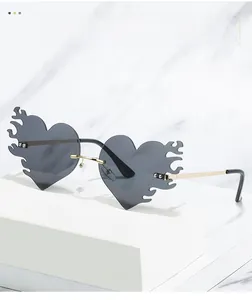 Detail der grauen Herz-Flammen-Sonnenbrille mit goldenem Metallsteg auf Marmorbasis