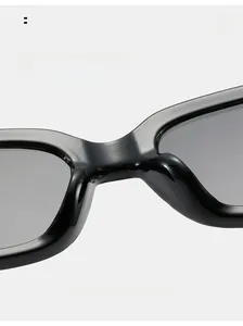 Détail de lunettes de soleil carrées avec plaquettes de nez intégrées et finition noire brillante